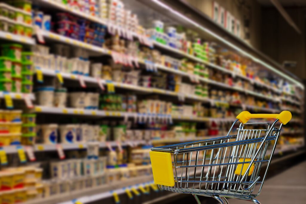 Geocery aisle in a supermarket with a trolley in the foreground